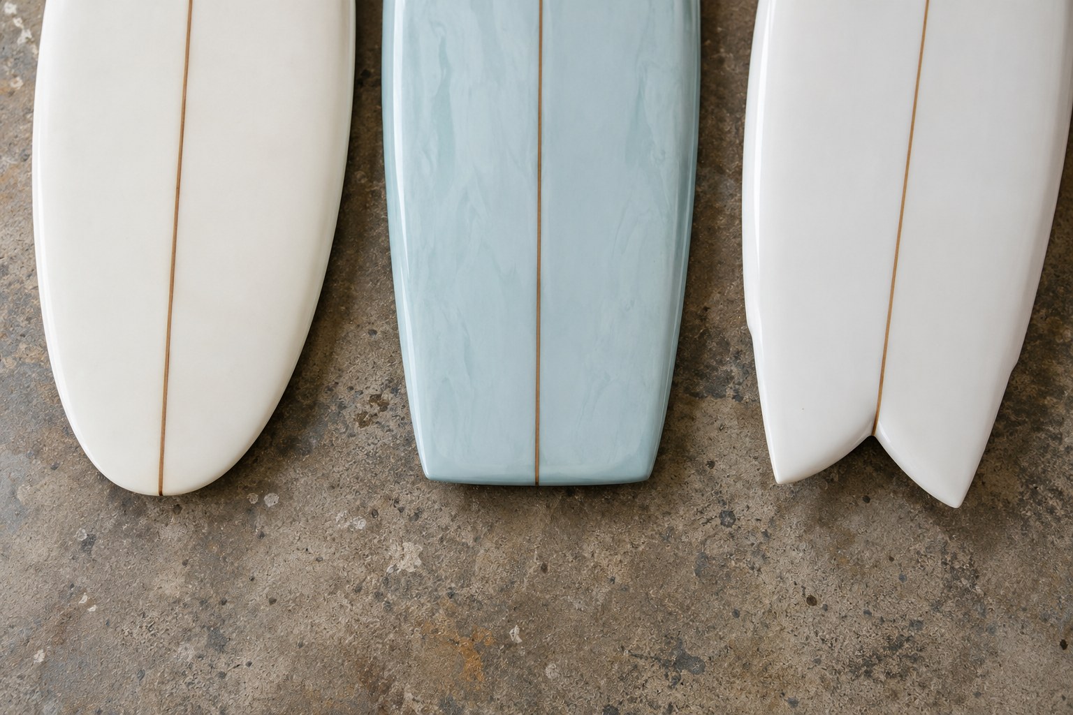 Rounded, square and swallow surfboard tails stand beside one another.