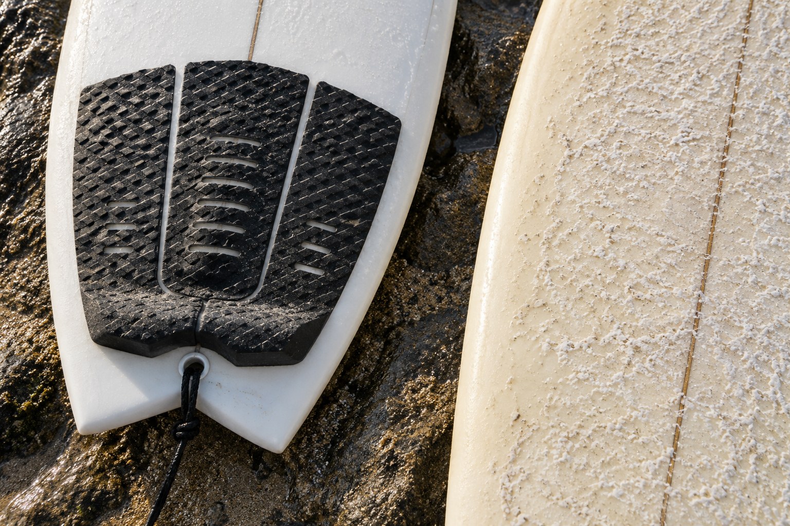 A textured traction pad and a waxed deck show two surfboard grip surfaces.